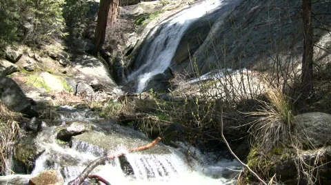Small waterfalls flows down the rocks into a creek Stock Footage 365267