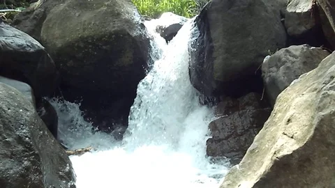 Small waterfalls stream on big river coming through between two big rocks Video stock 123758179