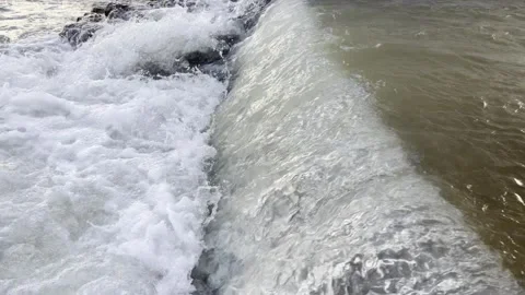 Small waterfalls from under a bridge on a mountain river, late morning. Stock Footage 330498612