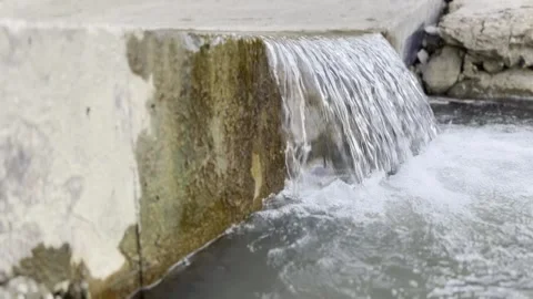 Small waterfalls from under a bridge on a mountain river, late morning. Stock Footage 330498837