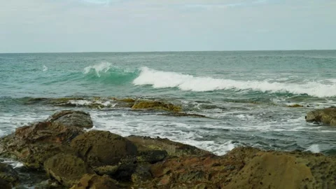 Small wave breaking over rocky shore Stock Footage 274345425