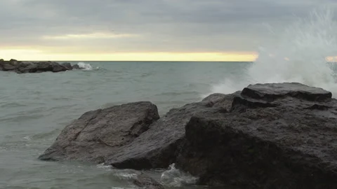 A small wave breaks over rocks Stock Footage 132584960