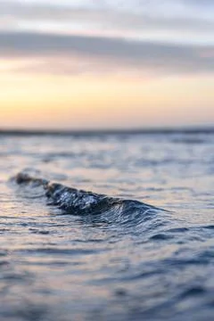 Small wave in center frame at sunset. Atmospheric sea view with blurred bac.. Stock-Fotos