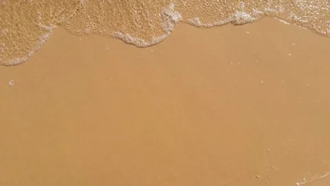 Small wave with clear water rolls onto sandy shore. Top view, empty space f.. Stock-Footage 284761842