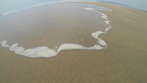 Small wave flowing through the beach sand Stock Footage 107879879