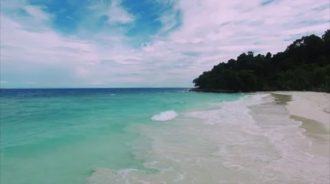 Small wave folding onto an empty tropical sand shore 库存影片 60735966