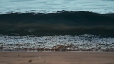 Small wave is moving towards the sandy beach in slow motion 4x, close up. Quiet Vídeo Stock 300868704