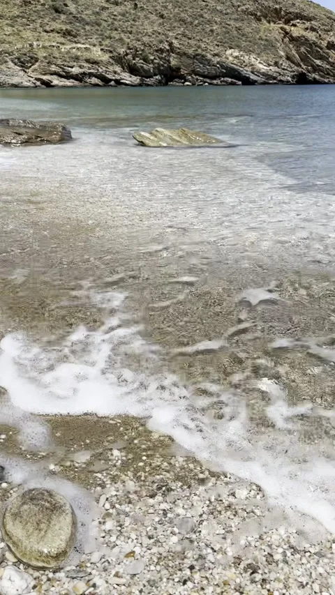 Small Wave Reaching Pebbled Beach in Peaceful Seaside Cove Stock Footage 336964901