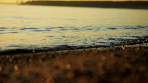 Small Wave Rolling onto Sandy Beach in Warm Sunset Light. Stock Footage 345311539