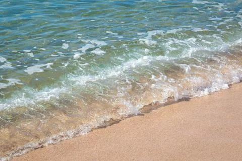 Small wave on sandy beach Stock Photos