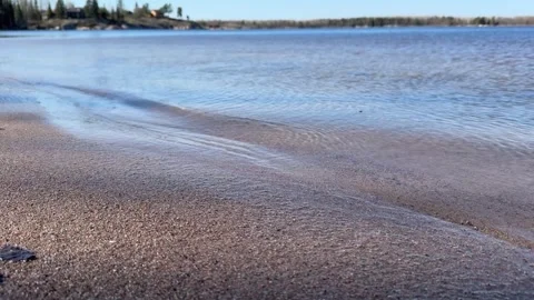Small wave on the sandy shore of the lake Stock Footage 309163271