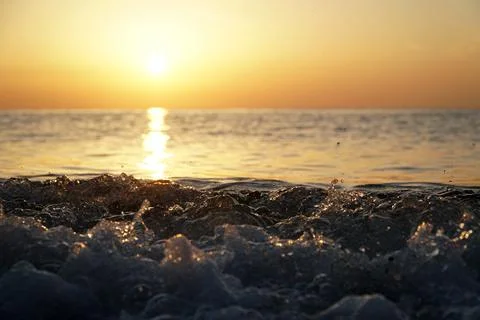 Small waves against the backdrop of sunset in the Mediterranean sea Stock Photos