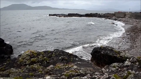 Small Waves and Water Flowing on Rocky Beach at Sea Coast of Ireland Stock Footage 77838372
