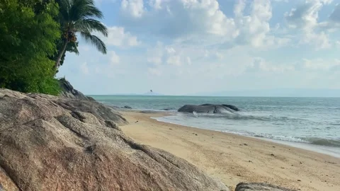 Small waves are beating against the sandy shore on a small beach. Stock Footage 230083395