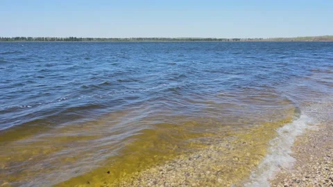 Small waves are breaking on a shoreline of small stones  Stock Footage 172217737