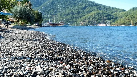 Small waves are hitting the stones continously at a beach in nature Stock Footage 113765723