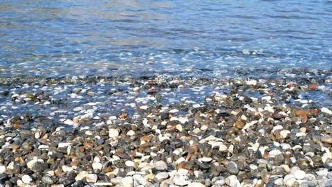 Small waves are hitting the stones continously Stock Footage 113822676