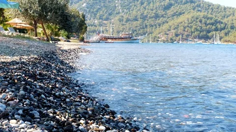 Small waves are hitting the stones continously at a beach in nature Stock Footage 113822745