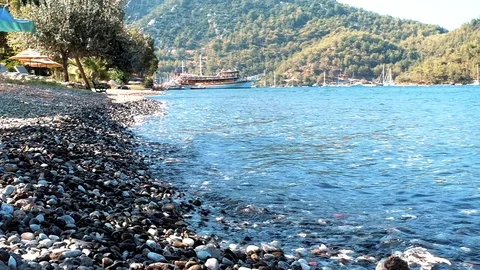 Small waves are hitting the stones continously at a beach in nature Stock Footage 113823113