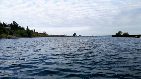 Small waves on the background of a beautiful sky. Video from the pier and the vi Stock Footage 108057045