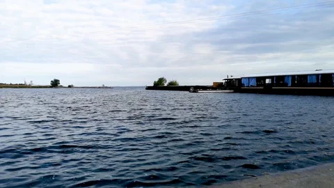 Small waves on the background of a beautiful sky. Video from the pier and the vi Stock Footage 108057132