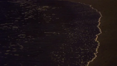 Small waves on beach at night time SLOW MOTION foamy ocean waves evening. Stock Footage 101212105