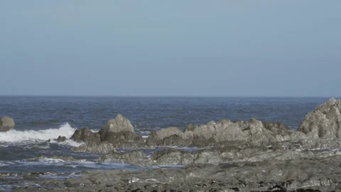Small waves break on rocky shore Stock Footage 136914516