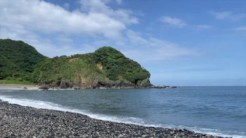 Small Waves Breaking Along A Grey Pebble Beach Below A Rounded Headland Stock Footage 342821377