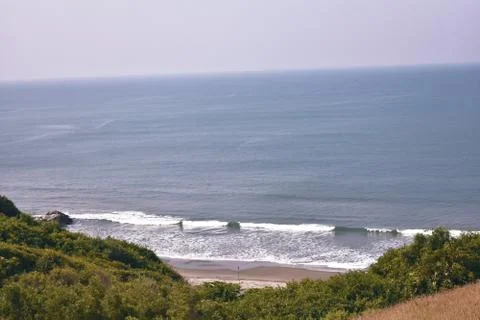 Small waves breaking in the blue ocean near a beach Stock Photos