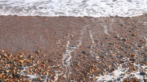 Small waves breaking on a pebble beach Stock Footage 941883