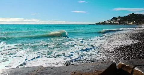 Small waves breaking on a pebbly beach in the Italian sea Stock Footage 240470631