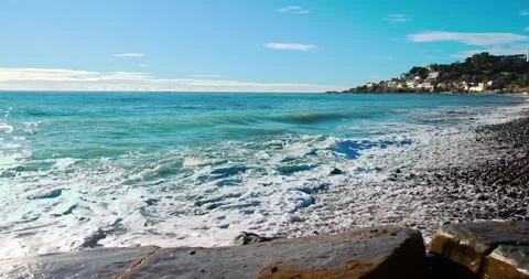 Small waves breaking on a pebbly beach in the Italian sea Stock Footage 240470831