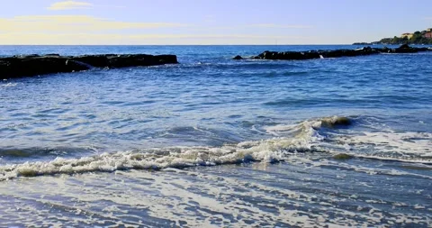 Small waves breaking on the reefs in the Italian sea Stock Footage 240470382