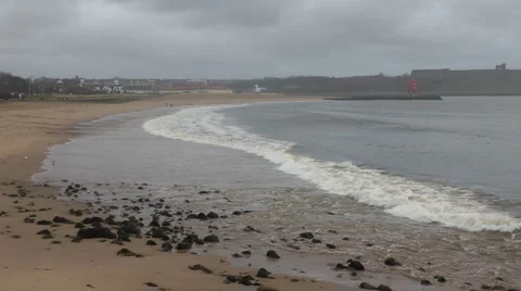 Small waves breaking onto sandy beach in winter Stock Footage 1091261