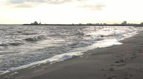 Small waves breaking with young male walking away &amp; towards camera, Australia Stock Footage 11242803