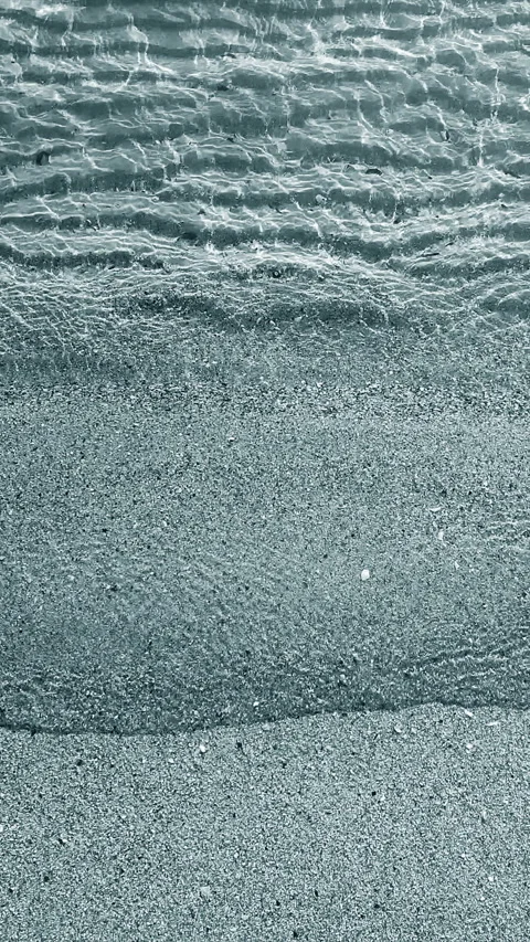 Small waves of clean transparent water rolling onto sand of shore on sunny day Stock Footage 295685273