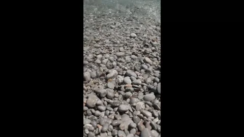 Small waves in clear blue sea. Pebble stone beach. Stock Footage 316920484