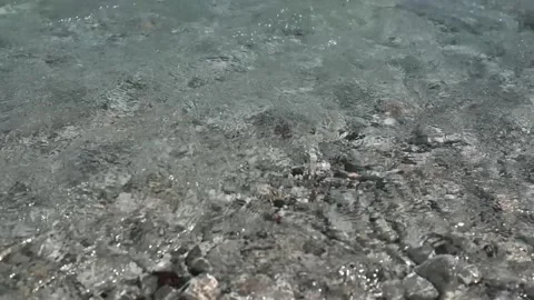 Small waves in clear blue sea. Pebble stone beach. Stock Footage 316920492