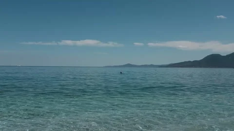 Small waves in clear blue sea. Pebble stone beach. Stock Footage 316920498