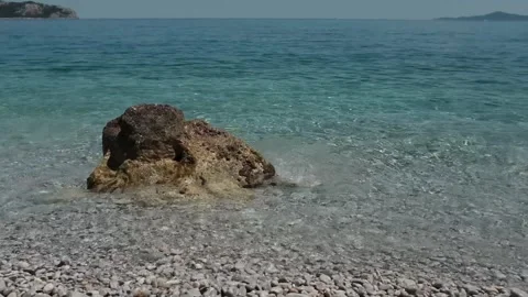 Small waves in clear blue sea. Pebble stone beach. Stock Footage 316920504