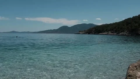 Small waves in clear blue sea. Pebble stone beach. Stock Footage 316920509
