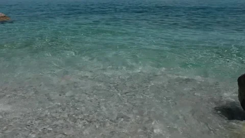 Small waves in clear blue sea. Pebble stone beach. Stock Footage 316920516