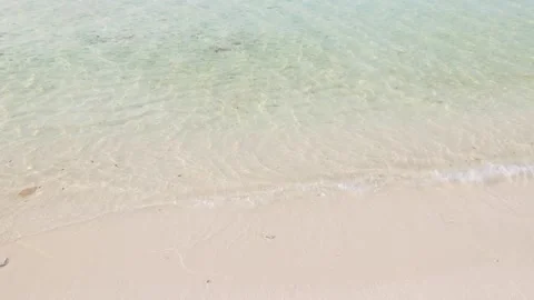 Small waves of clear turquoise ocean water and sandy beach Stock Footage 306292912