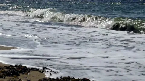 Small waves crashing on a sandy beach on a sunny day. 스톡 동영상 40216856