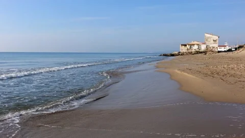 Small waves on Elche beach in the morning. In the background a white house. Stock Footage 153239139