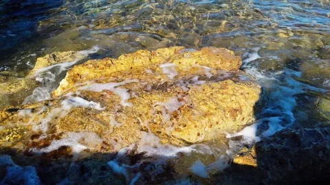 Small waves with foam splash on the stones on the beach in the morning Stock-Footage 287802887