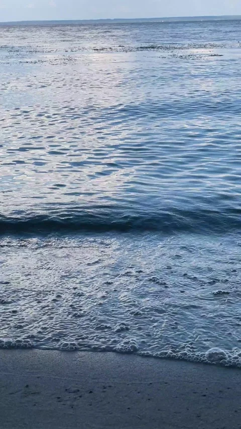 A small waves gently wash onto the sandy shore. Stock Footage 281683656