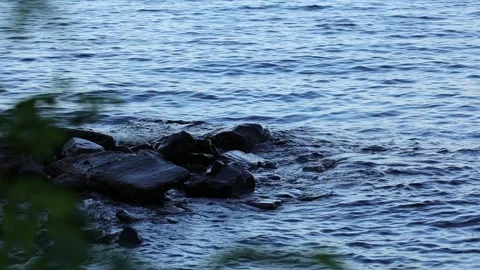 Small waves hit the rocky shore Stock Footage 245359741