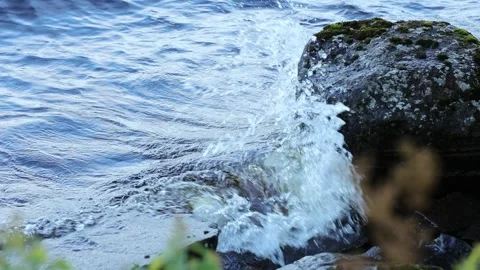 Small waves hit the rocky shore Stock Footage 245359744
