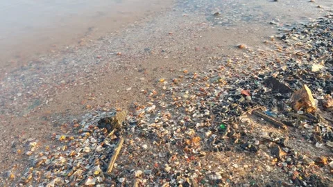 Small waves hit the sand and small rocks Видео 337679845
